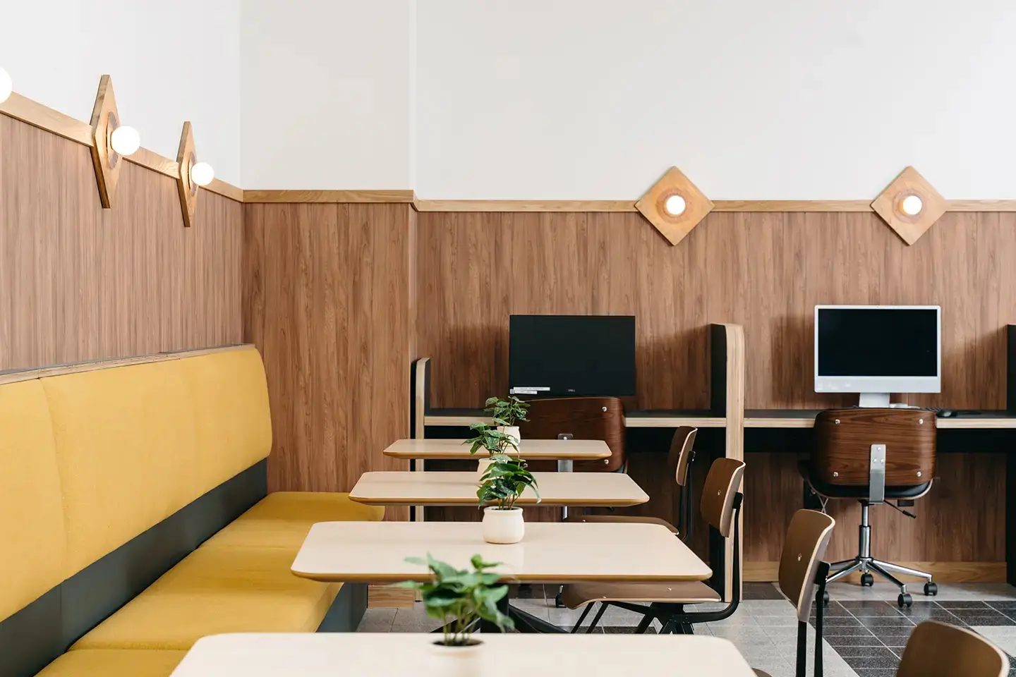 Booth, tables, chairs and desktop computers at The Verge